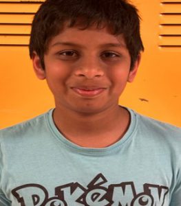 A close up of a student standing in front of yellow lockers
