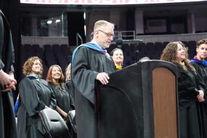Principal speaks at podium at graduation ceremony