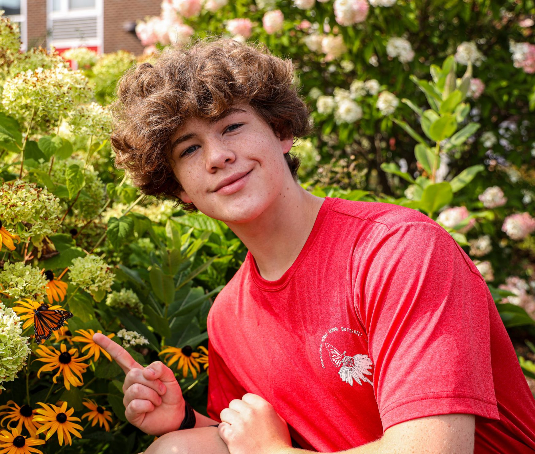 Student at FMS Butterfly Release pointing at butterfly.