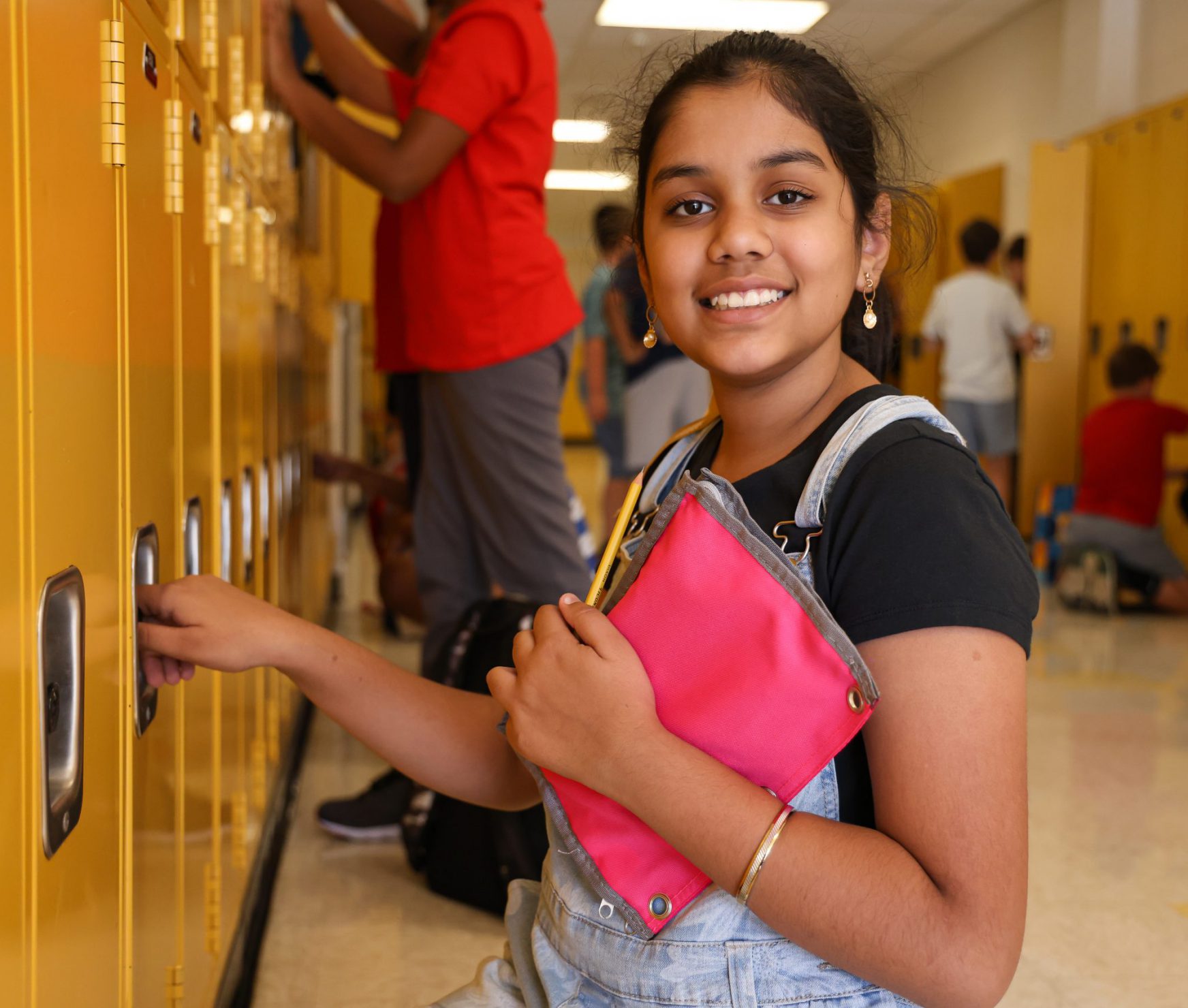 Student smiling next to locker on the first day of school.