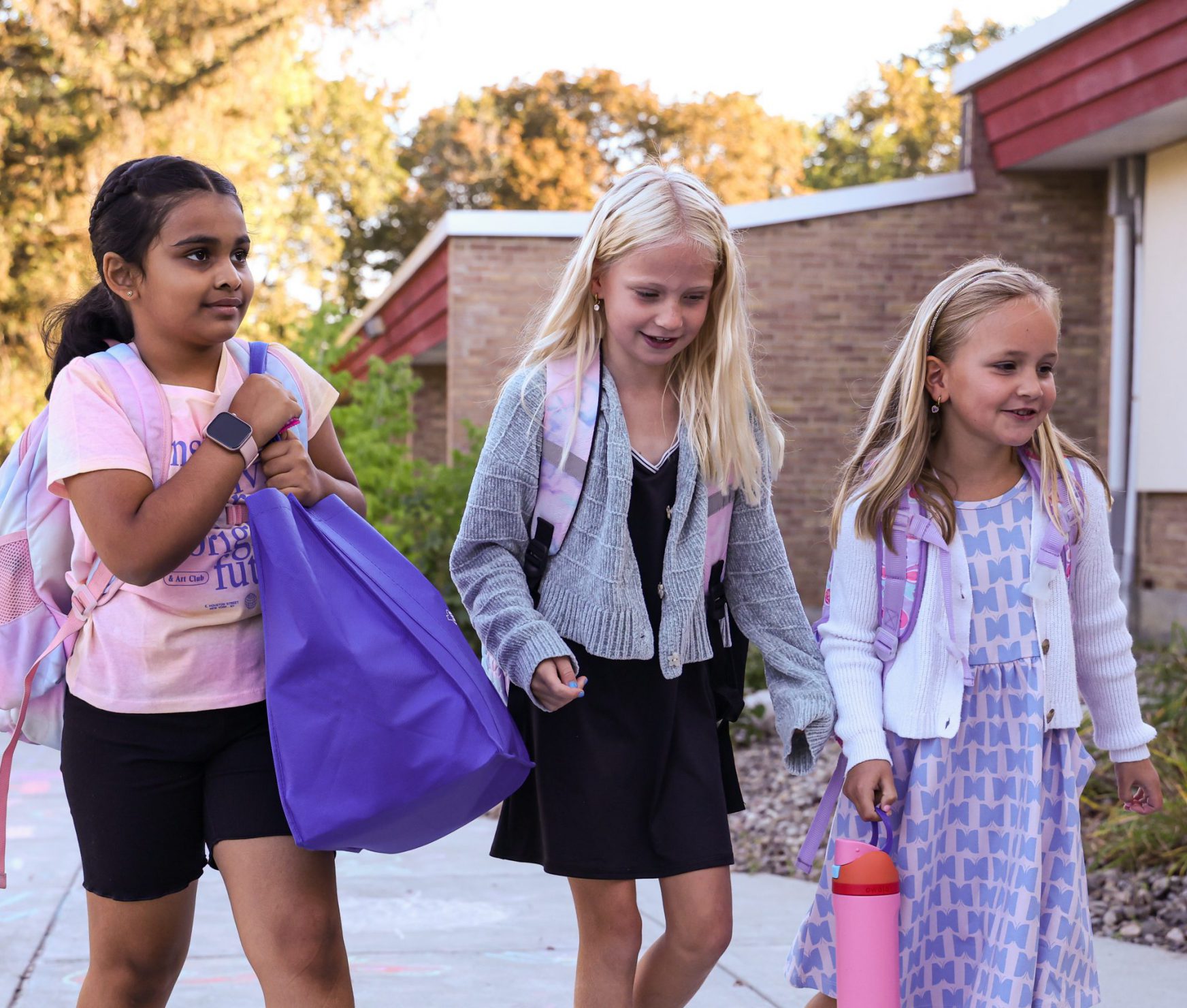 Three students walking into school.