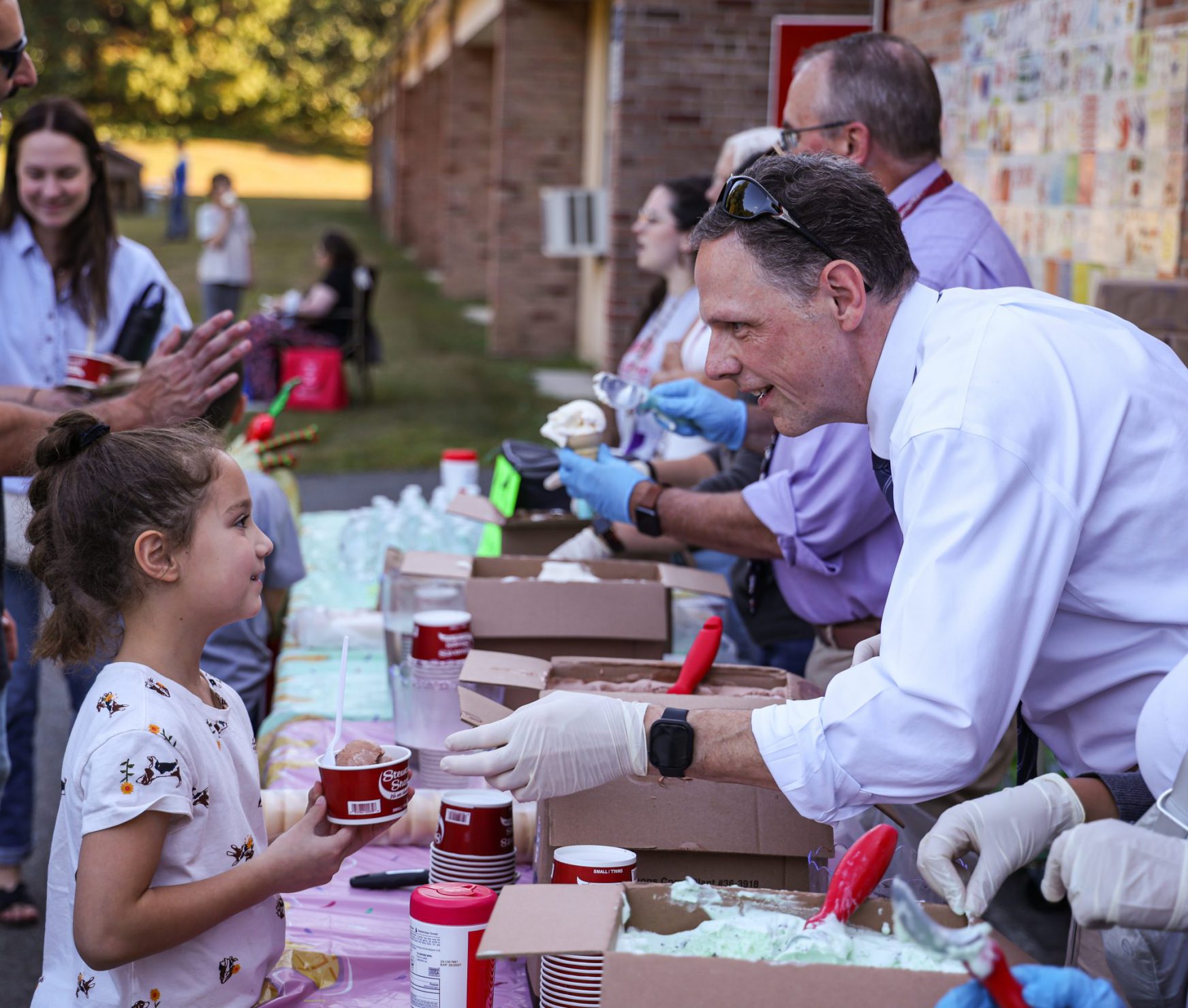 GCSD Superintendent handing ice cream to student. They are both smiling.
