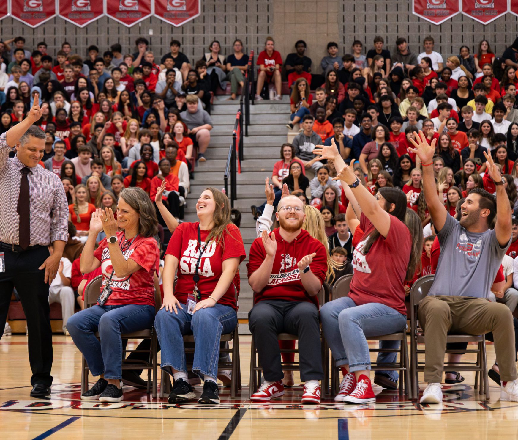 GHS staff playing musical chairs at spirit rally and smiling.