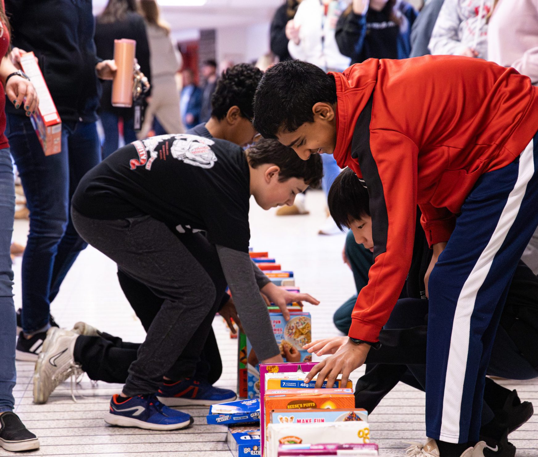 FMS student smiling as he sets cereal box into a row.