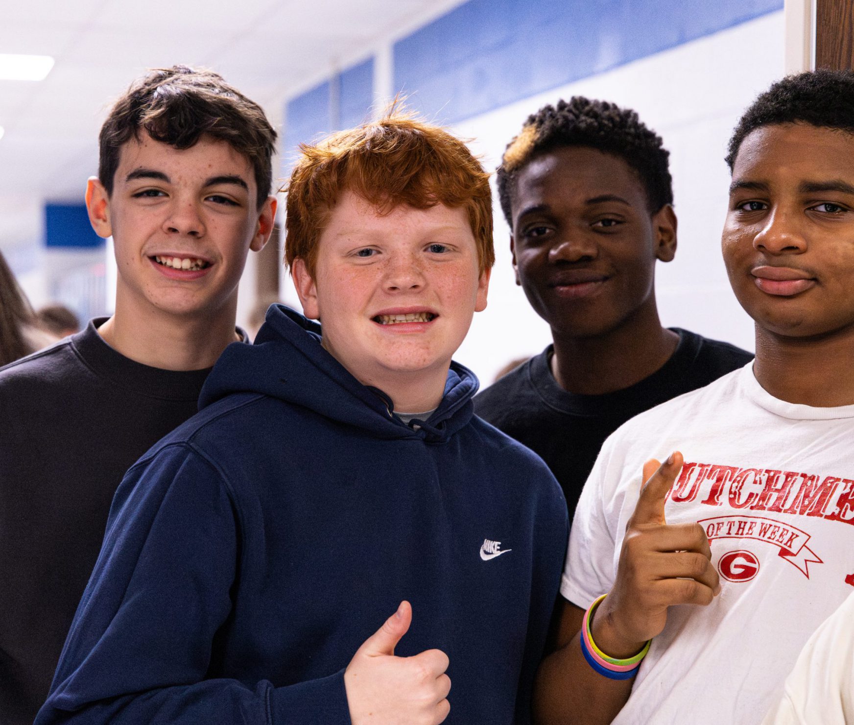 Four FMS students smiling in the halls.