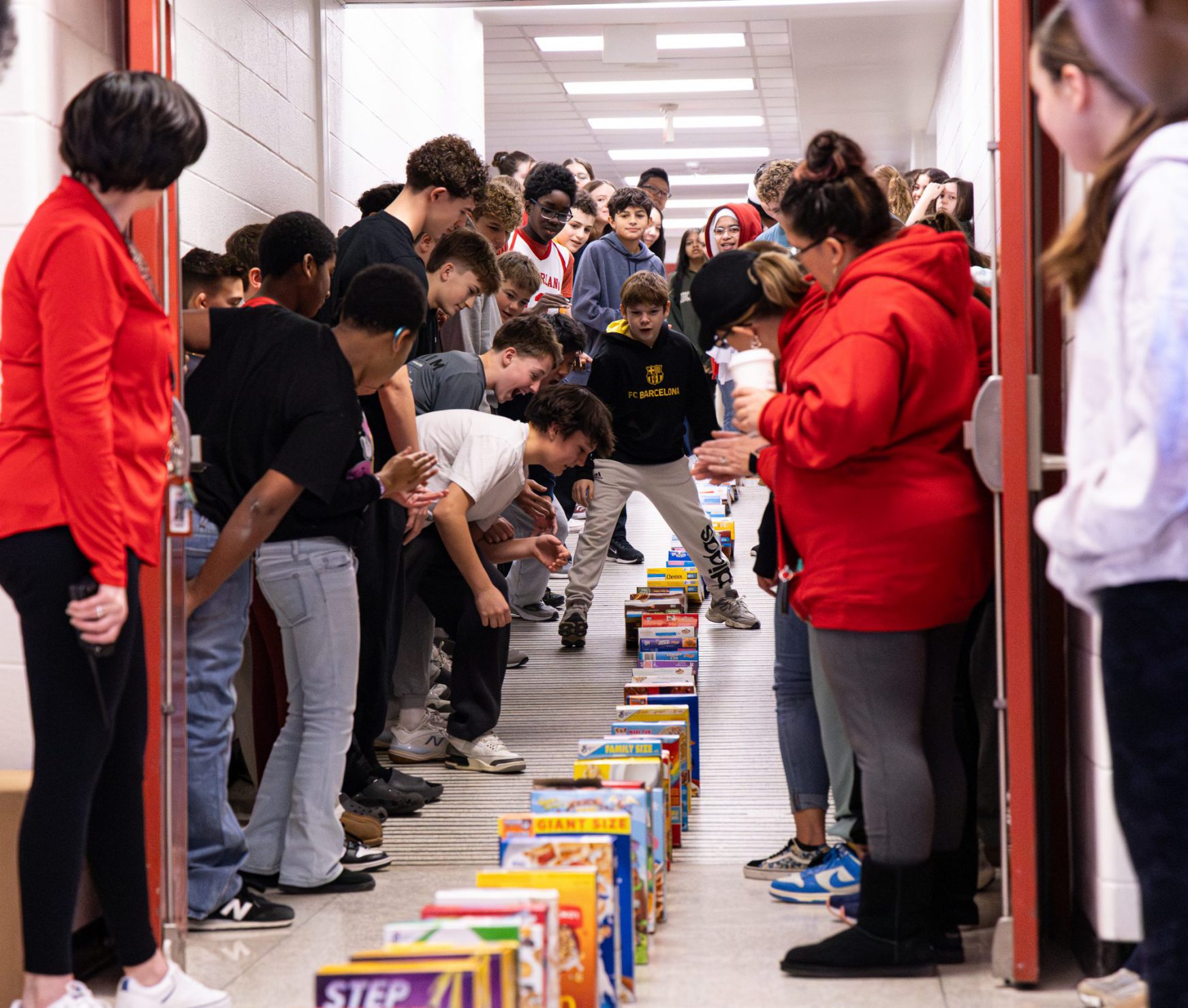 FMS students watching cereal boxes fall in the halls. They are smiling.