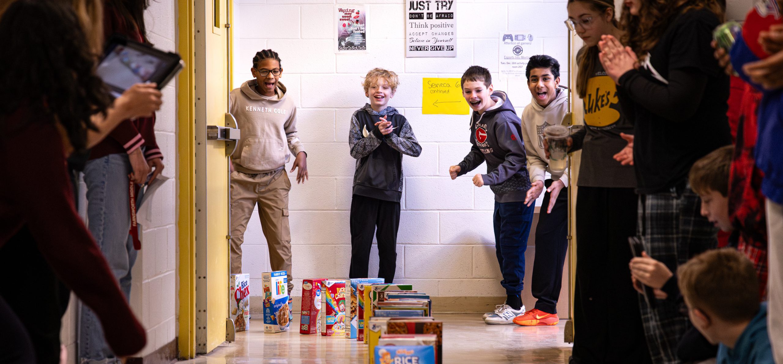 FMS students smiling in the halls as cereal boxes domino through the school.
