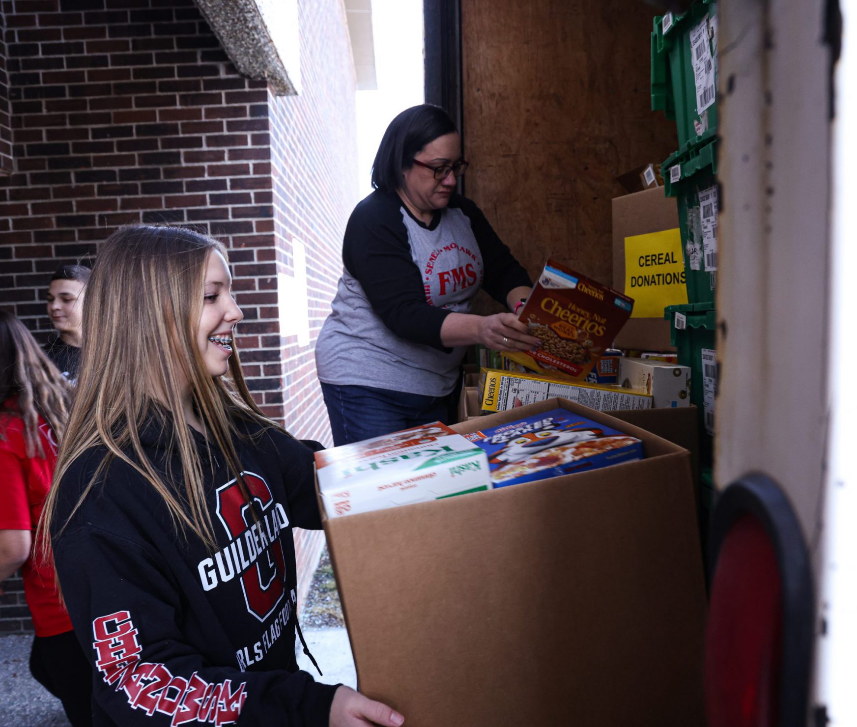 FMS students loading truck with cereal boxes.