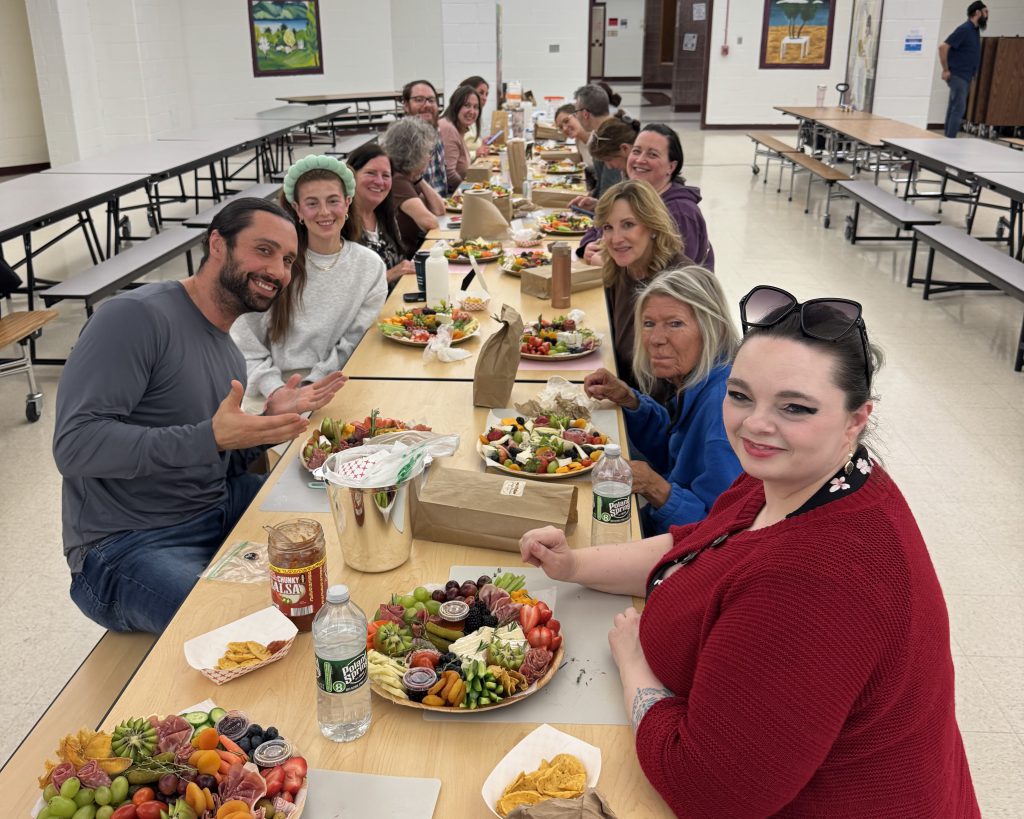adults at long table by their newly crafted charcuterie boards